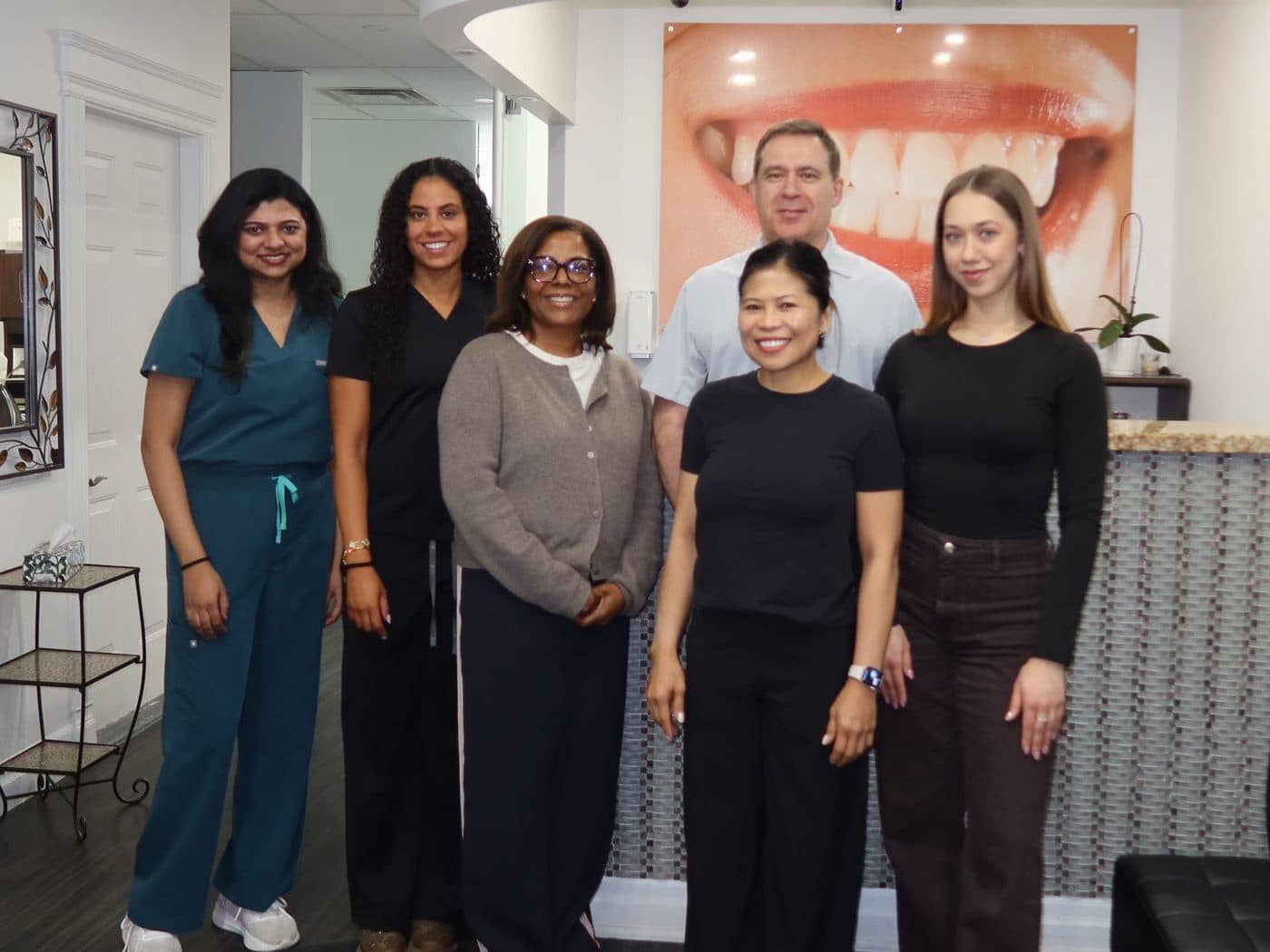 The Elgin Mills dental team — six smiling staff members in the Richmond Hill clinic reception.