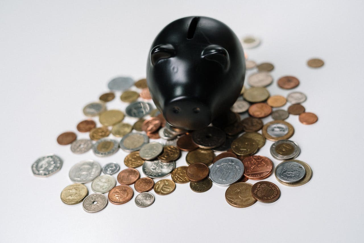 Piggy bank surrounded by coins representing dental implant costs