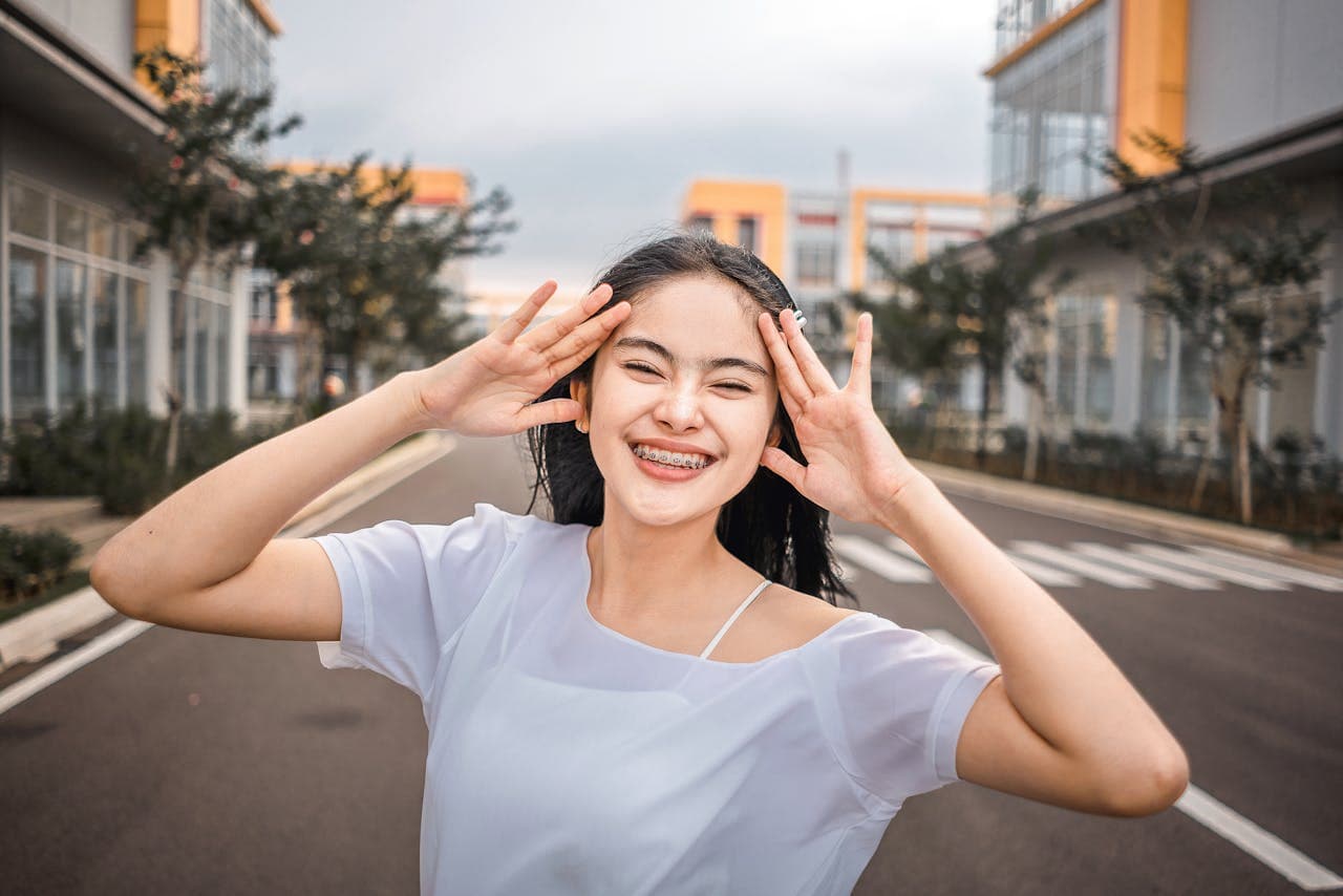 Smiling teenager wearing metal braces outdoors